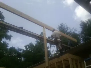Carpenter setting a ridge beam over a new addition frame — Ice Dam Removal by Roofing Brothers in East Andover