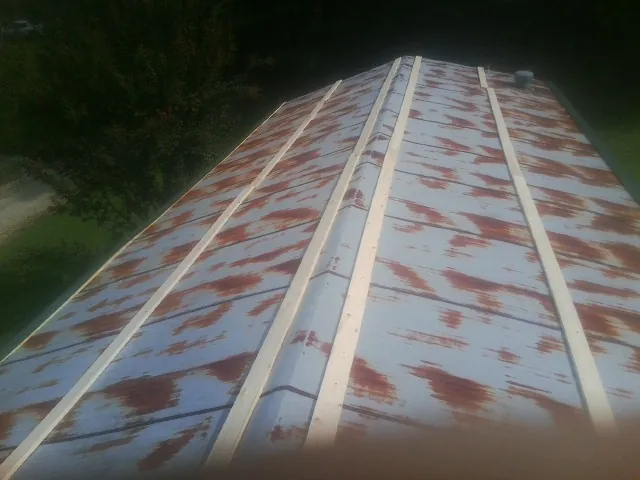 Rusted metal roof panels with new wood purlins before replacement — Storm Damage Roof Repair in East Andover by Roofing Brothers