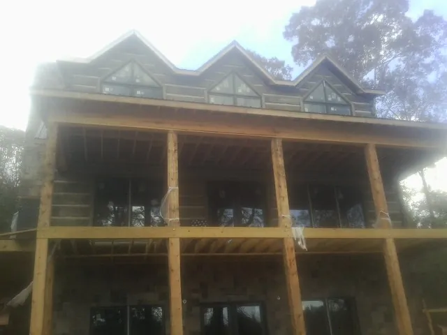 Dormers and porch framing on a large log home under construction — Roof Coating work by our crew in East Andover