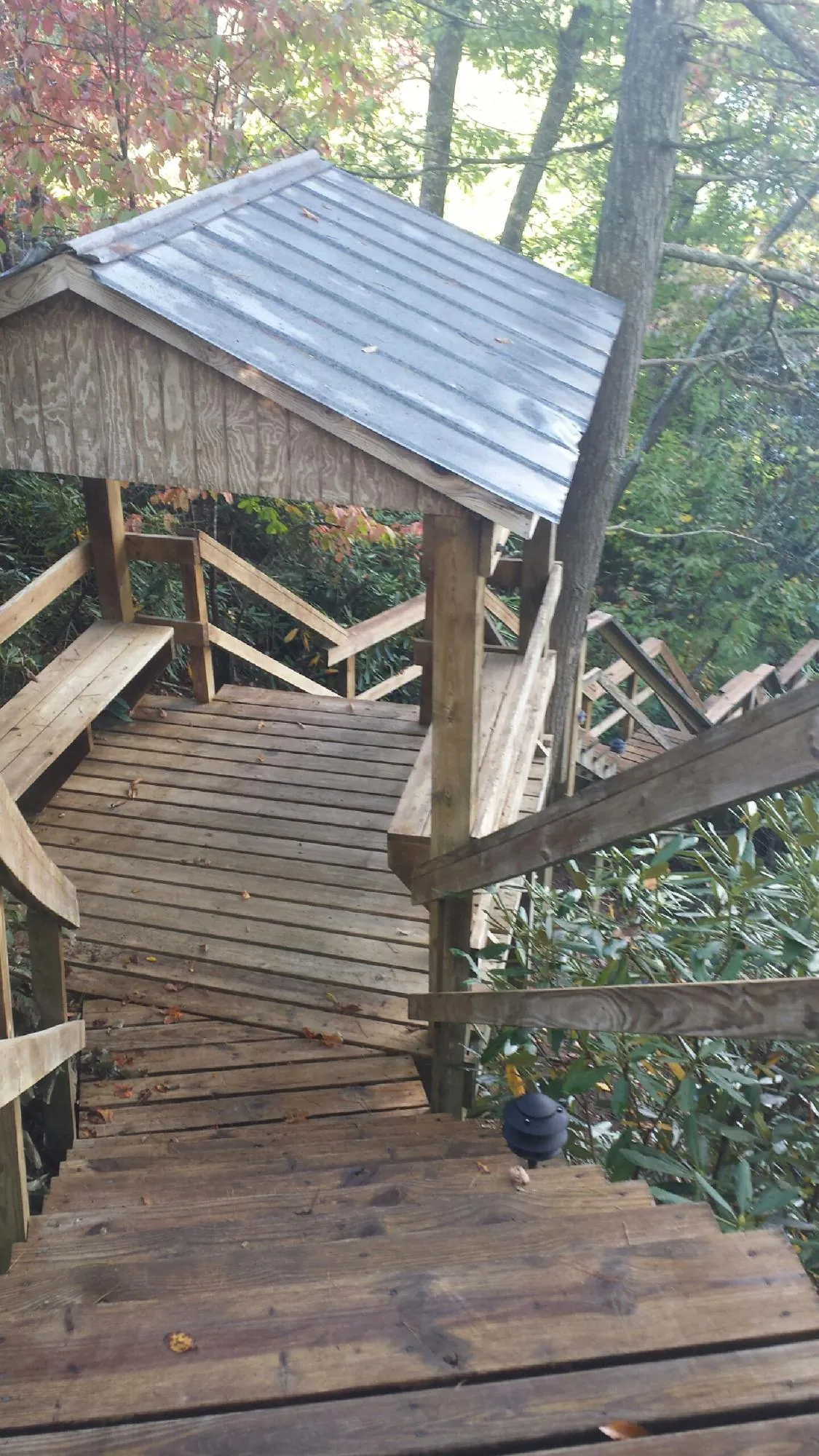 Metal roofed shelter over wooden steps on a wooded walkway — Skylight Repair & Installation work by our crew in East Andover