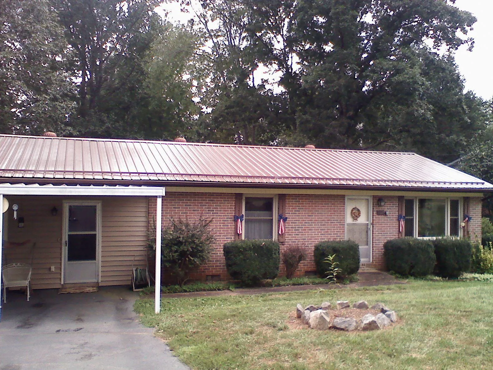 Bronze metal roof and carport on a brick ranch home — Roof Repair work by our crew in East Andover